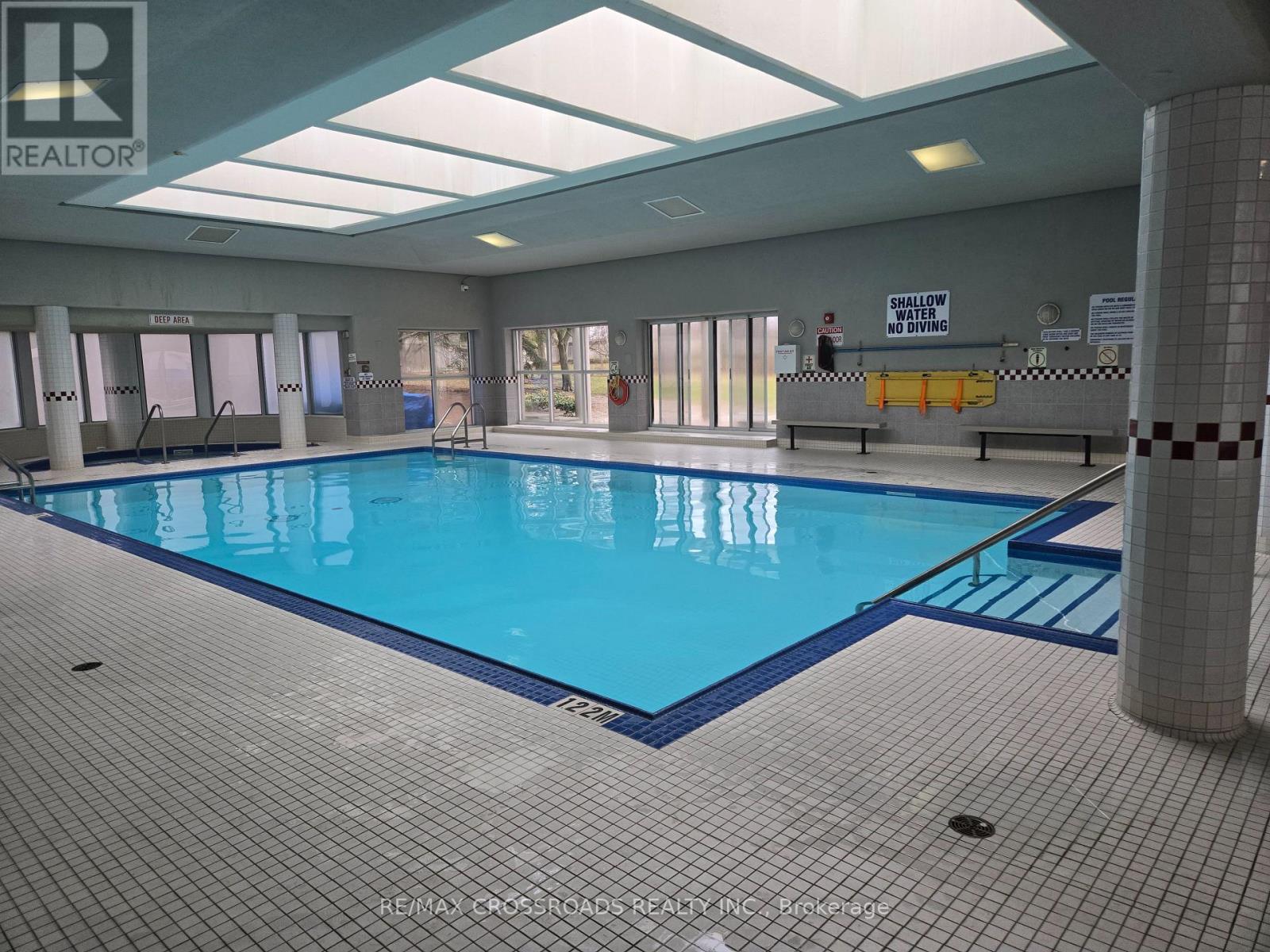 A large indoor swimming pool with a sign that says "SHALLOW NO DIVING".