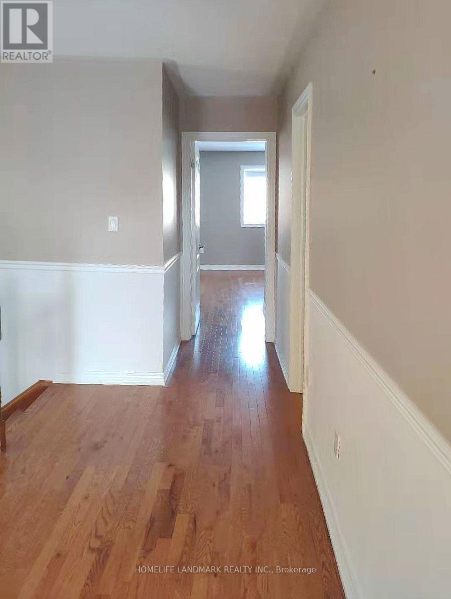 A hallway with wood floors and white walls.