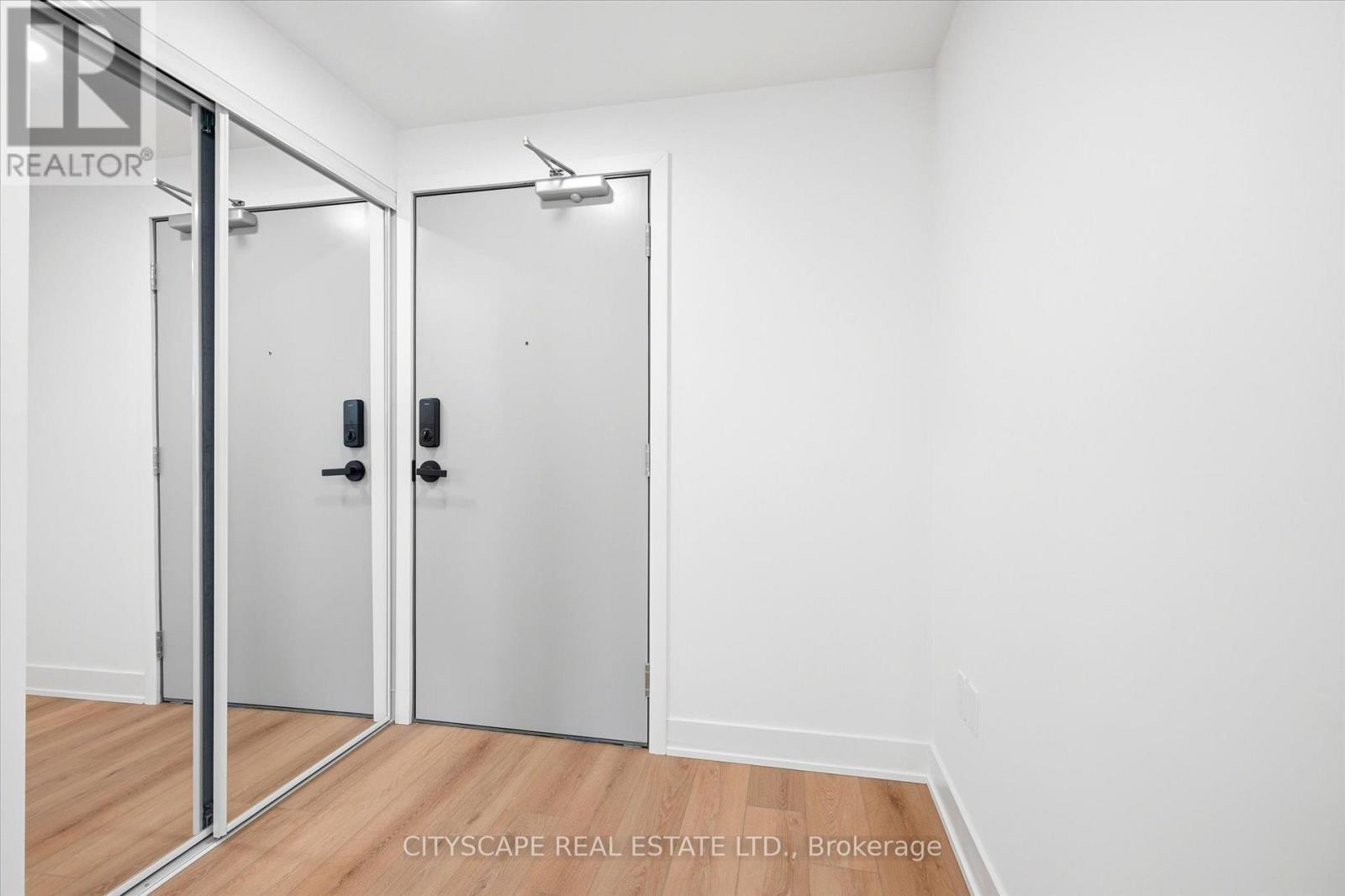 A white room with a mirror and a door.