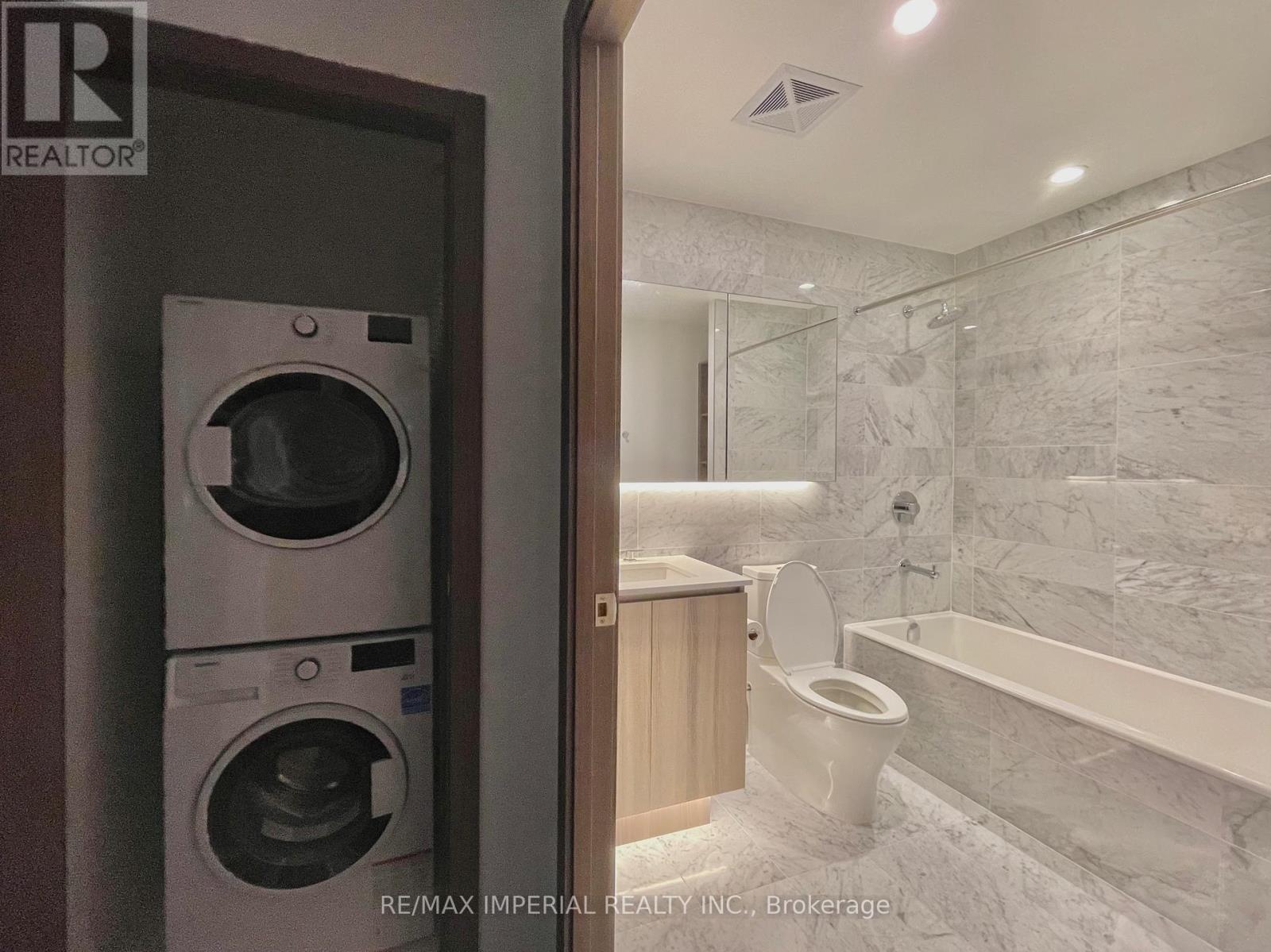 A bathroom with a washer and dryer built into the cabinet.