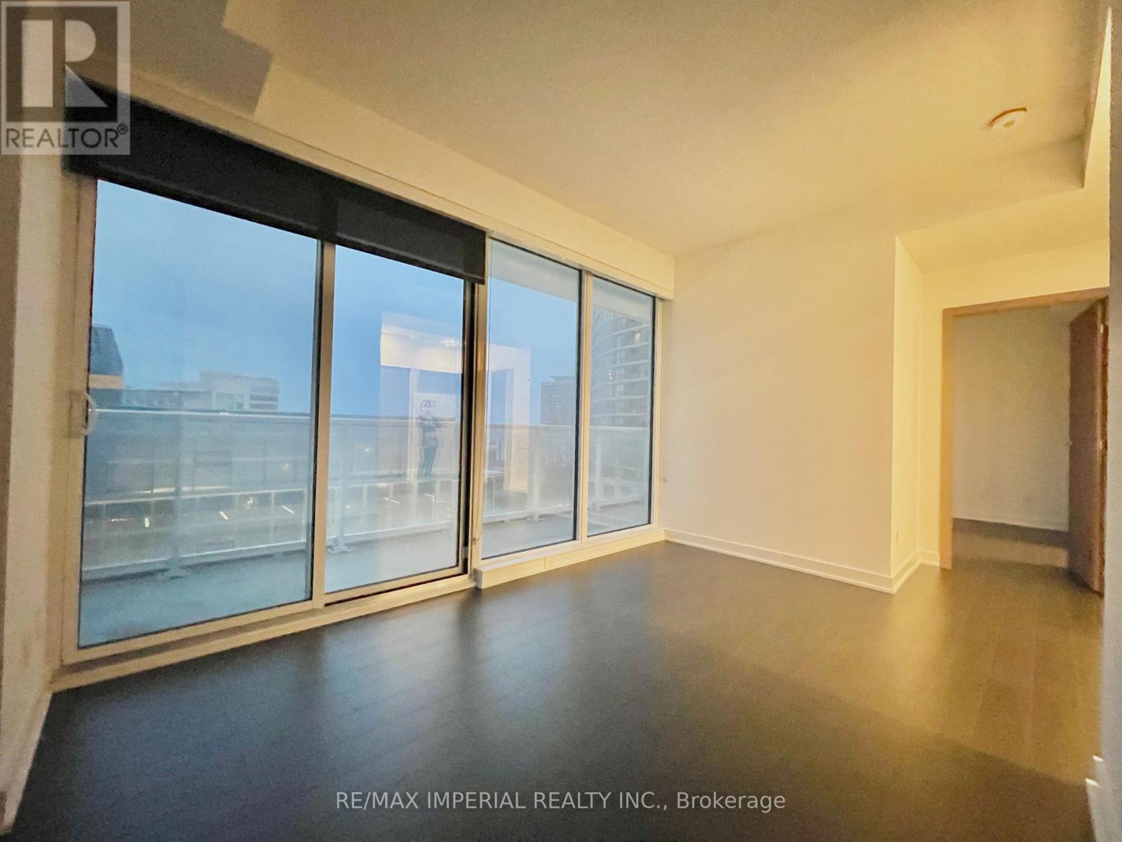A spacious room with large windows and a view of the city.