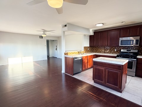 A kitchen with dark wood cabinets and a white countertop.