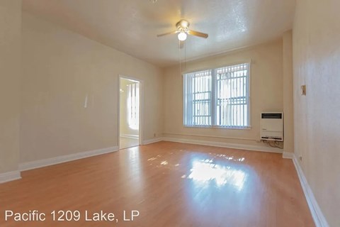 A room with a ceiling fan and a window with blinds.