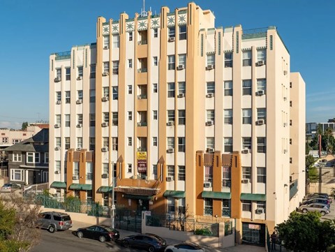 A large white building with a green awning and a brown sign on the front.