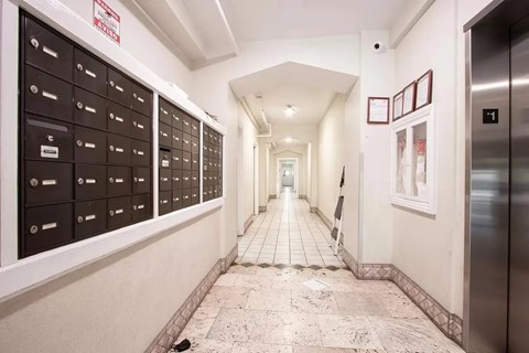 A long hallway with mailboxes on the wall and a sign that says "No Trespassing".