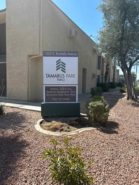 A sign for Tamarus Park is displayed in front of a building.