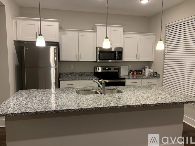 A kitchen with a granite countertop and stainless steel appliances.
