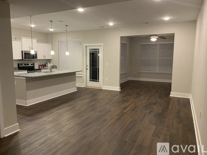A kitchen with wooden floors and a countertop with a microwave and oven.