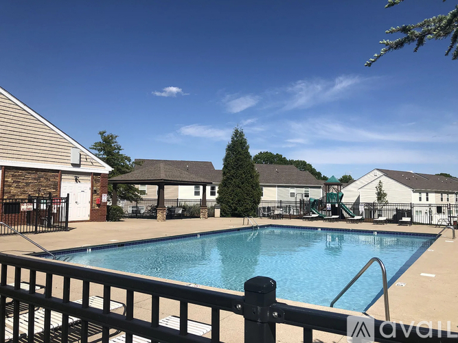 A pool surrounded by a black fence with a white sign on it.