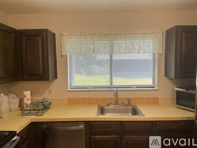 A kitchen with brown cabinets and a sink.