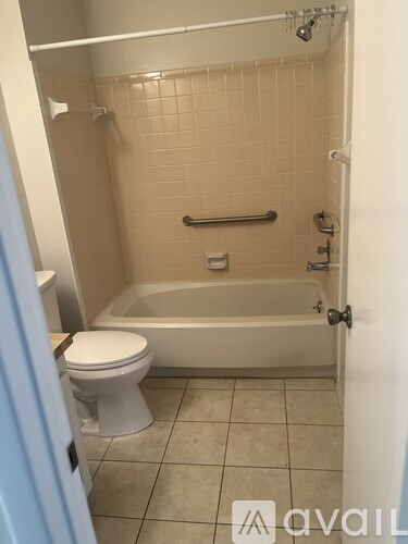 A bathroom with a toilet, tub, and tiled walls.