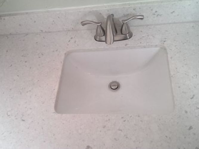 A white sink with a chrome faucet.