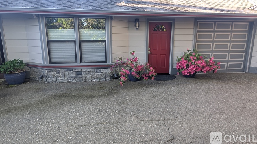 A house with a red door and a red flower pot in front.