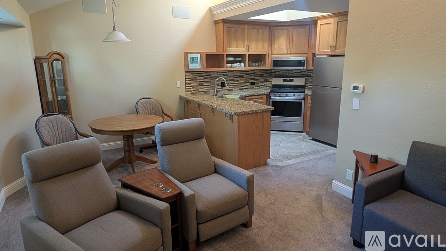 A kitchen area with a table and chairs.