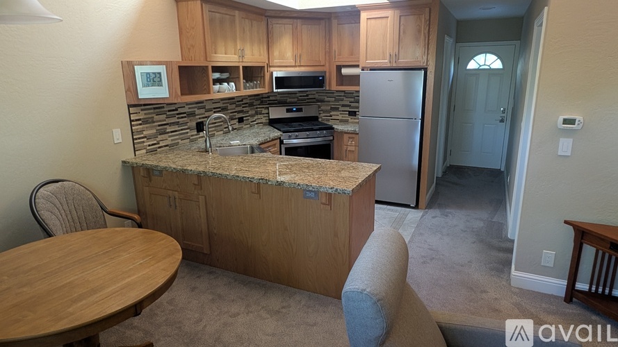 A kitchen with a table and chairs in front of it.