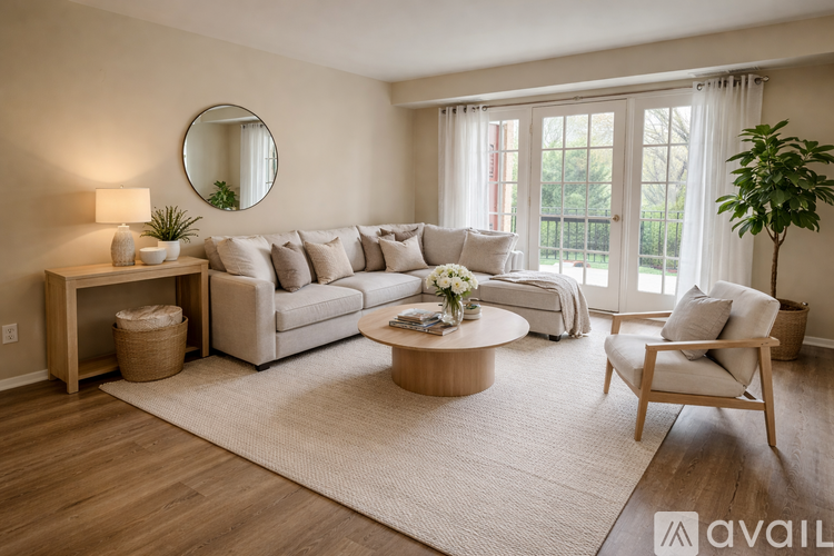 A living room with a large sectional sofa, a round mirror, a coffee table, and a potted plant.