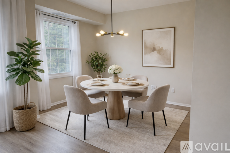 A dining room with a round table and chairs.