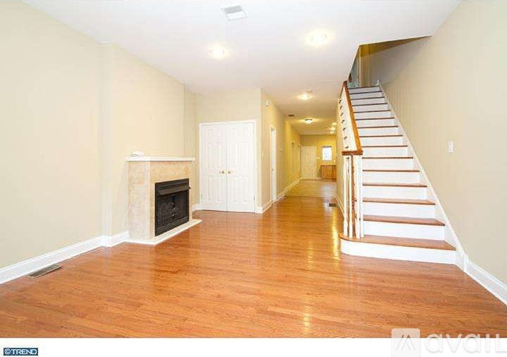 A living room with a fireplace and a staircase.
