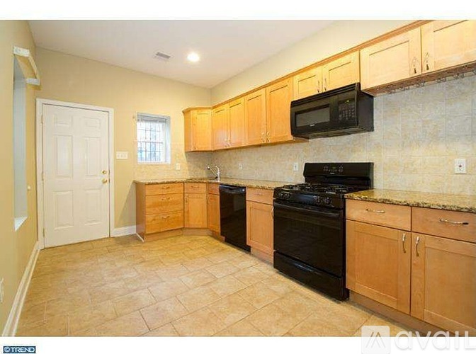 A kitchen with black appliances and wooden cabinets.