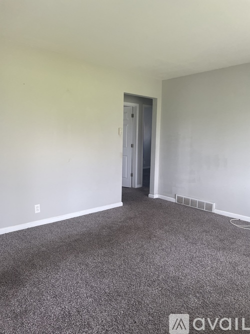A room with a carpeted floor and a door.