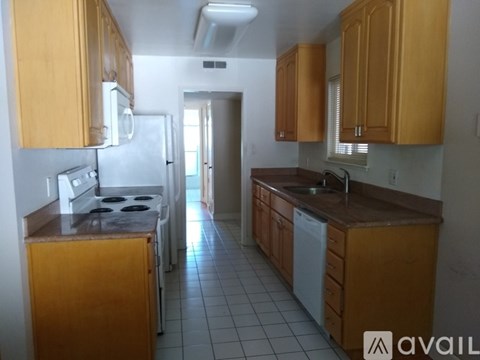 A kitchen with wooden cabinets and a white fridge.