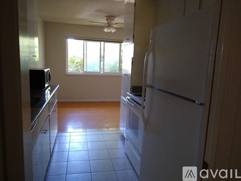 A kitchen with a white refrigerator and a ceiling fan.
