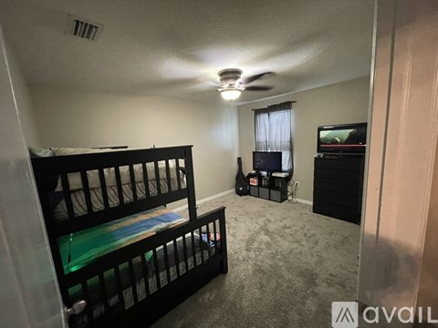 A bedroom with a bed, a chair, and a television.