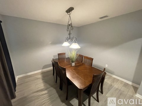 A dining room with a wooden table and chairs.