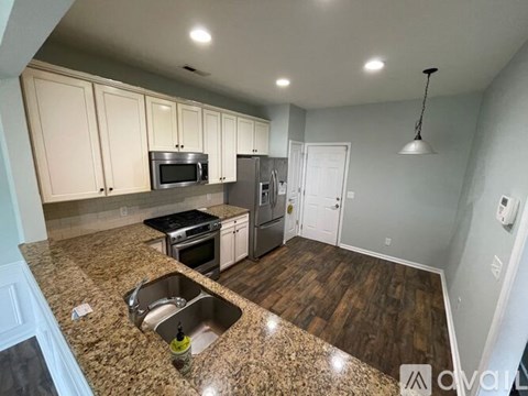 A kitchen with granite countertops and white cabinets.