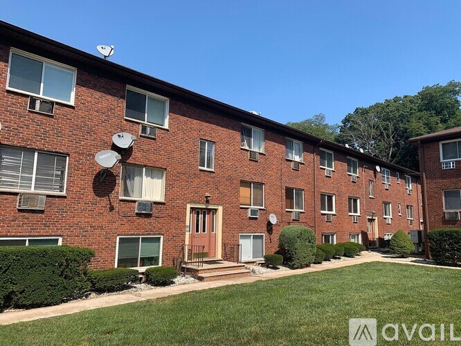A brick apartment building with a satellite dish on the roof.