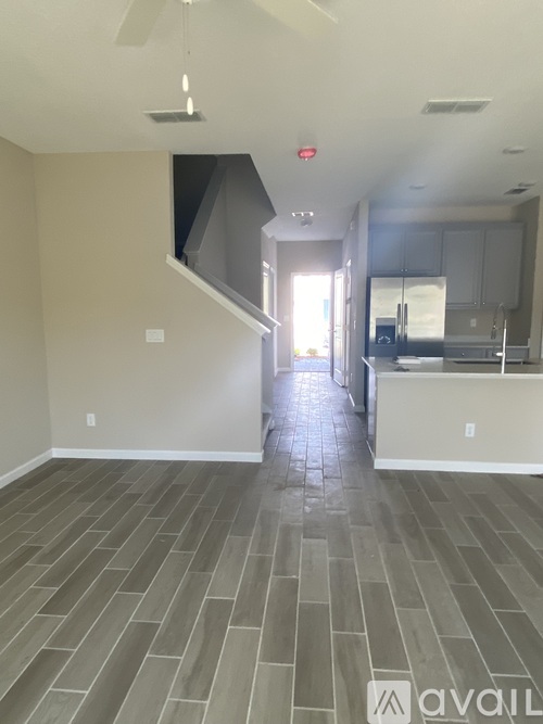 A spacious living room with a staircase leading to the upper level.