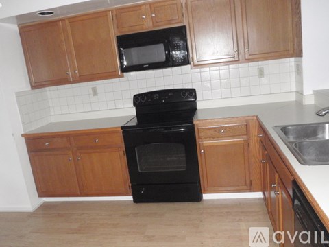 A kitchen with wooden cabinets and a black oven.