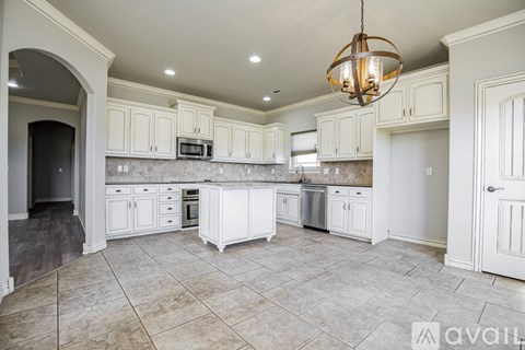 A kitchen with white cabinets and a tiled floor.