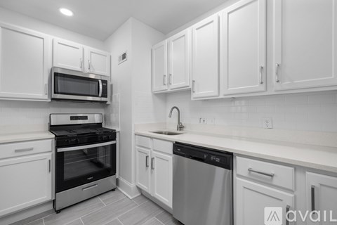 A kitchen with white cabinets and appliances.