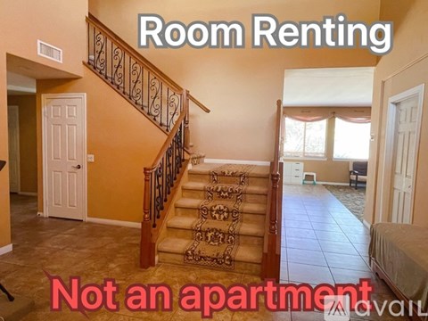 A room rental sign is displayed in a spacious room with a staircase.