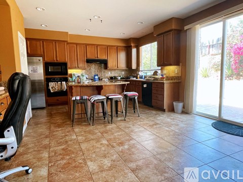 A kitchen with brown cabinets and a tiled floor.