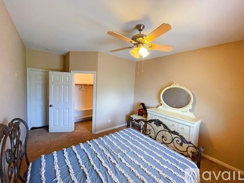 A bedroom with a bed, dresser, and mirror.