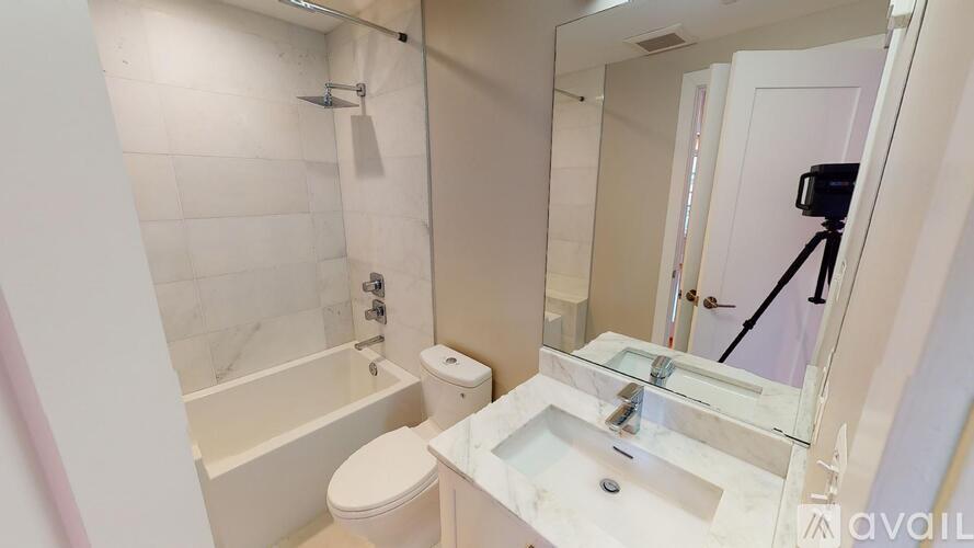 A bathroom with a white toilet, sink, and bathtub.