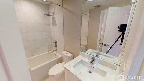 A bathroom with a white toilet, sink, and bathtub.