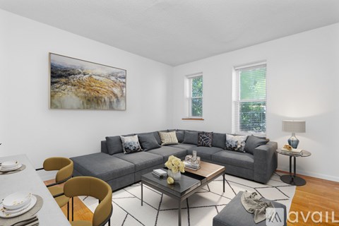 A living room with a grey couch, a coffee table, and a painting on the wall.