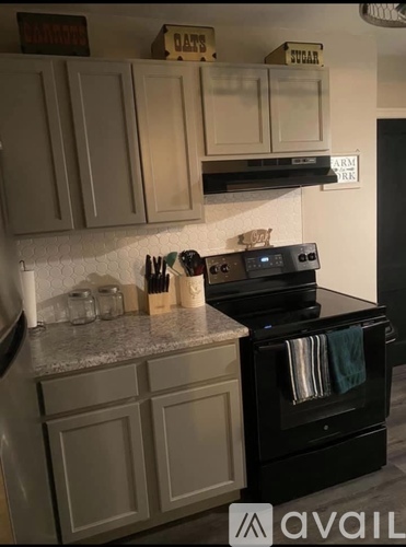 A kitchen with a black oven and white cabinets.