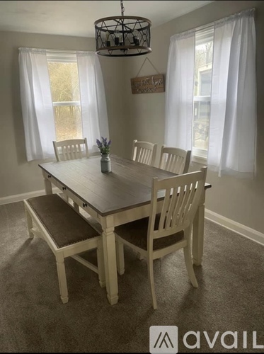 A dining room with a wooden table and chairs.