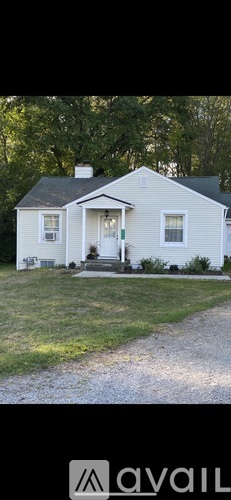 A white house with a gravel path leading to the front door.