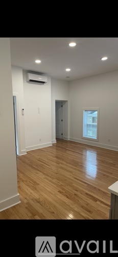 A room with wooden flooring and a window.