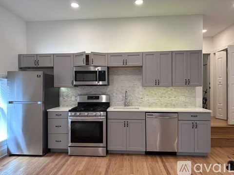 A kitchen with a stainless steel refrigerator, oven, and microwave.