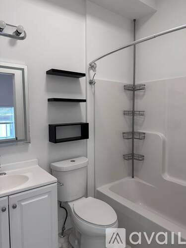 A white bathroom with a toilet, sink, and bathtub.