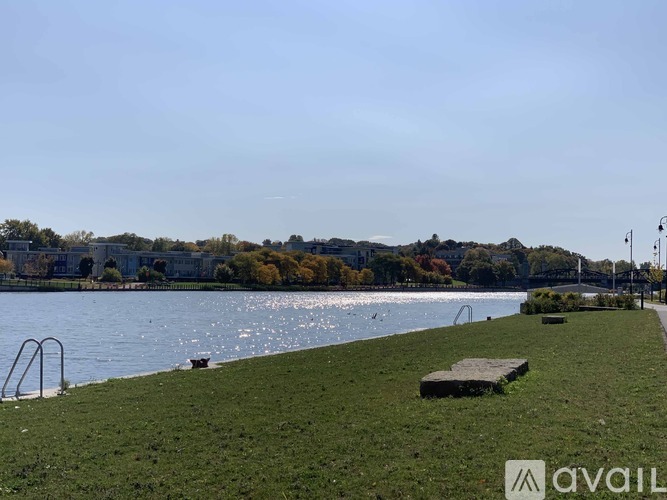 A park with a grassy area, a bench, and a body of water.