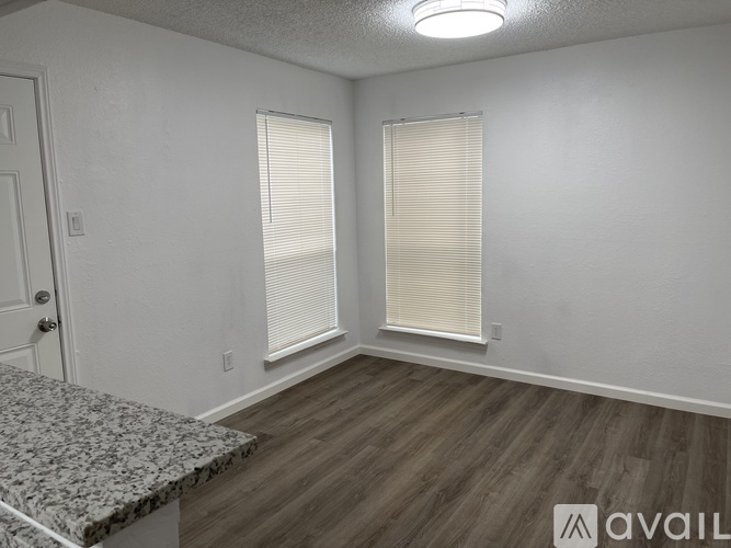 A room with a granite countertop and wooden flooring.