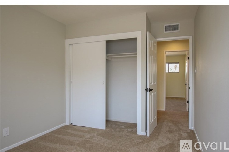 A room with a carpeted floor and a door leading to another room.