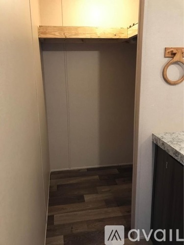A small room with a wooden floor and a white wall.